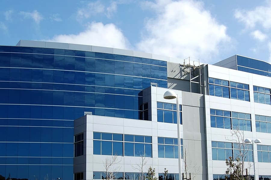 Blog - View of a Modern Office Building Displaying Dark Windows on a Sunny Day