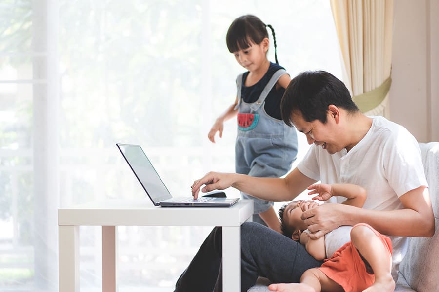 Personal Insurance - Father is Trying to Work From Home While the Children Play With Him
